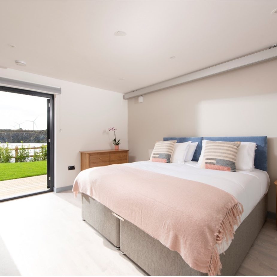 Spacious double bedroom with discreet ceiling hoist at Claire Milne House
