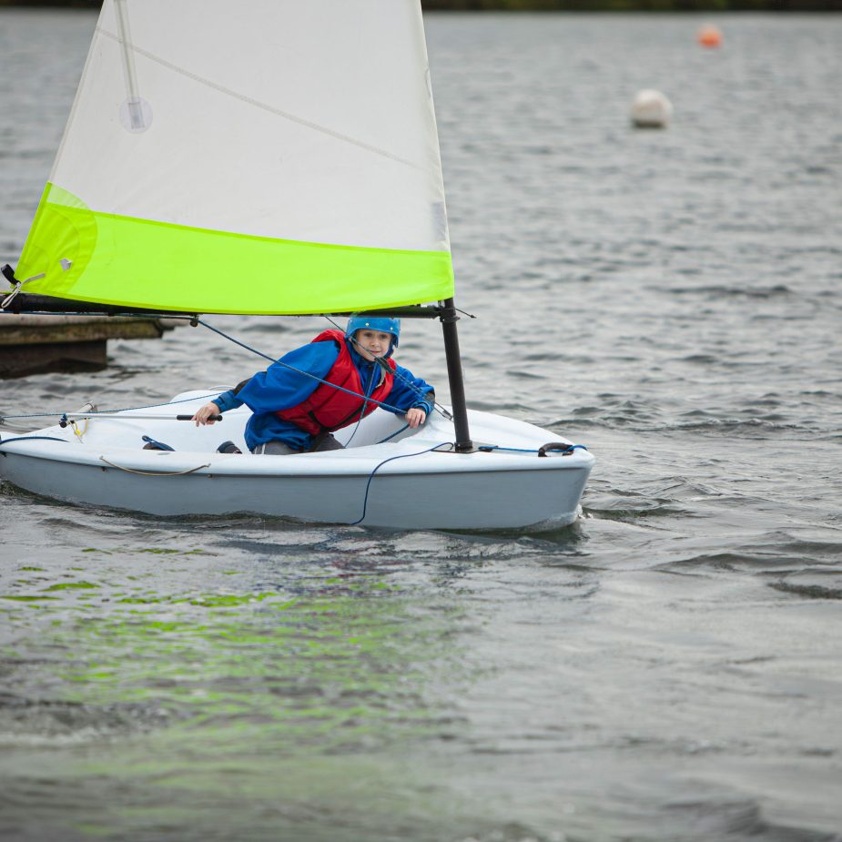 Young girl sailing boat on lake in Cornwall