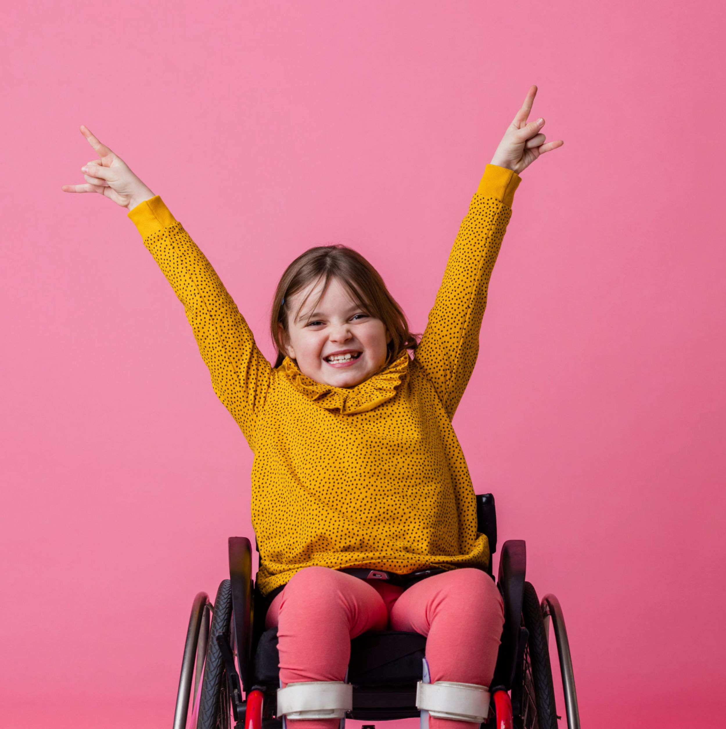 A smiling young girl in a wheelchair